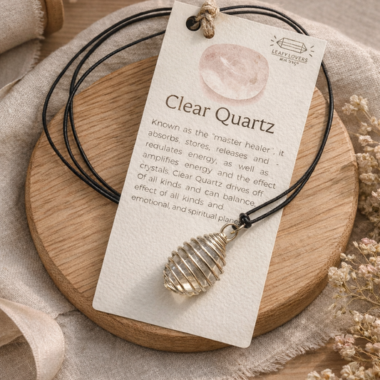 Clear quartz crystal necklace with wire wrapped pendant on adjustable cord displayed on oak background