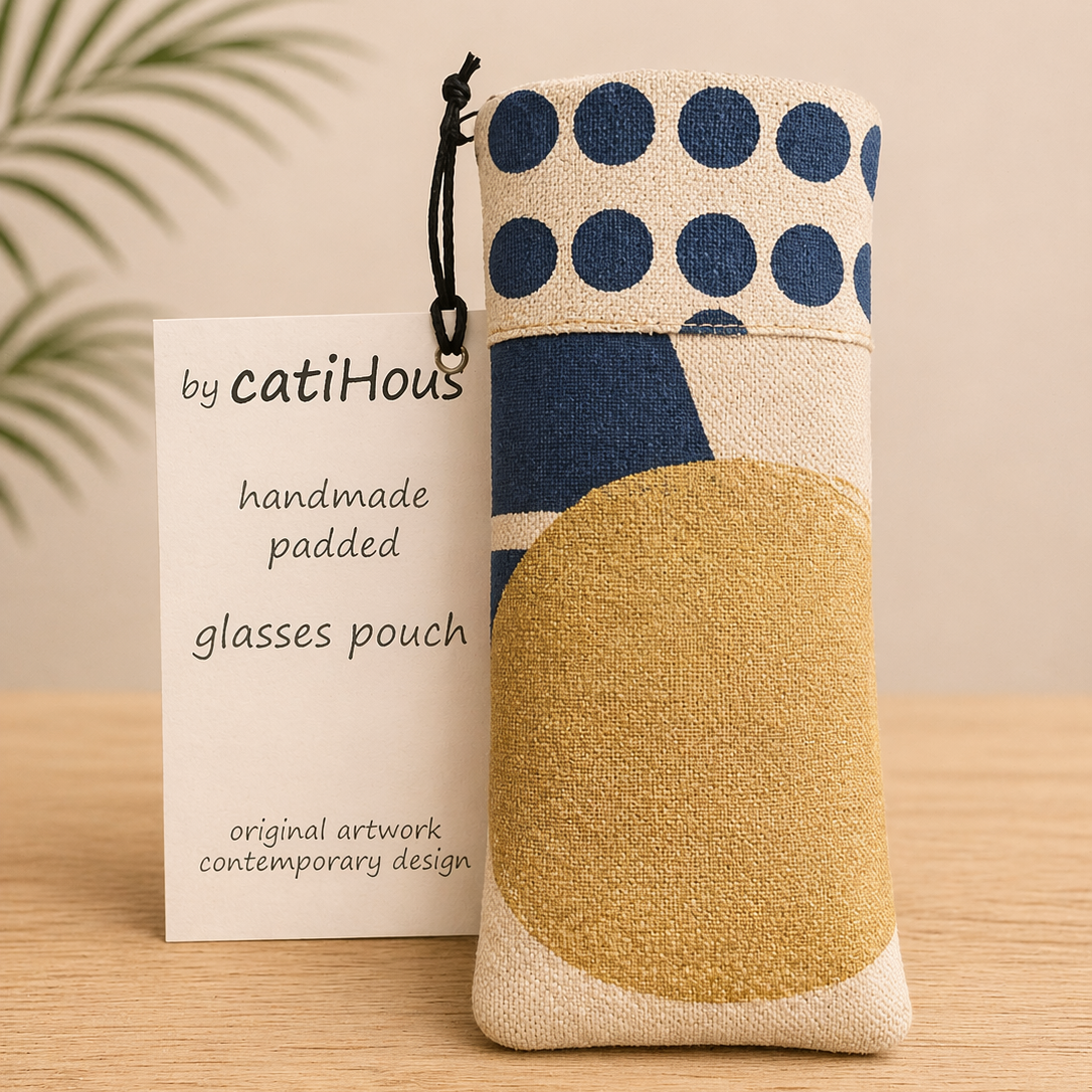 Handmade padded glasses pouch with contemporary print on light oak surface