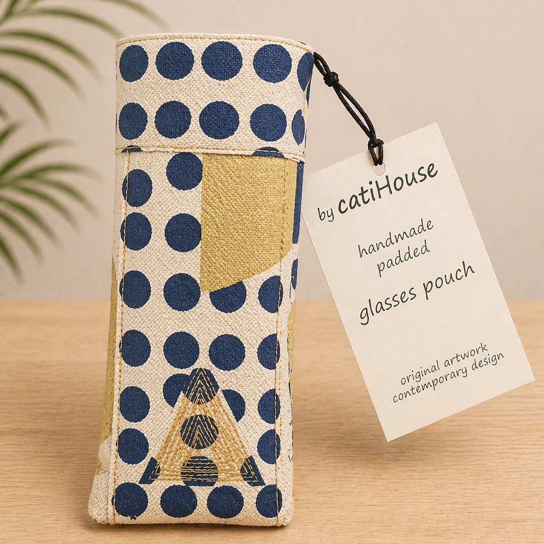 Handmade padded glasses pouch with contemporary print on light oak surface