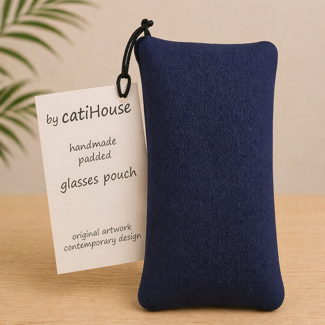 Handmade padded glasses pouch with pink and navy circular pattern on light oak surface