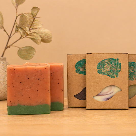 Handmade natural exfoliating soap bar displayed on light oak surface with eco-friendly packaging