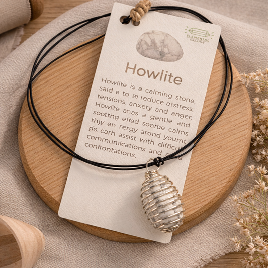 Howlite crystal necklace with wire wrapped pendant on adjustable cord displayed on neutral wood background