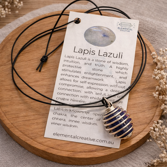 Lapis lazuli crystal necklace with wire wrapped pendant on oak background