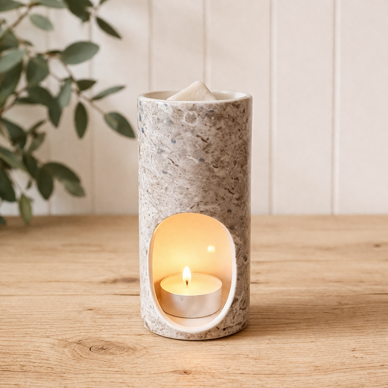 ceramic melt warmer with tealight candle on light oak surface minimal styling